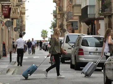 Unas turistas buscan su hospedaje en una zona de apartamentos turísticos