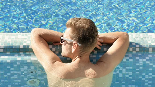 Imagen de un hombre tomando el sol en una piscina Imagen de un hombre tomando el sol en una piscina