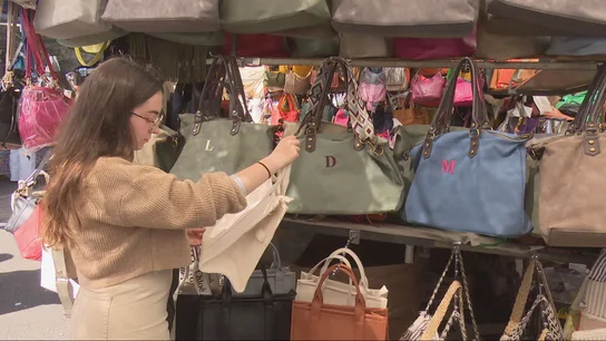 Una chica observa un bolso falsificado en una imagen de archivo. Una chica observa un bolso falsificado en una imagen de archivo.