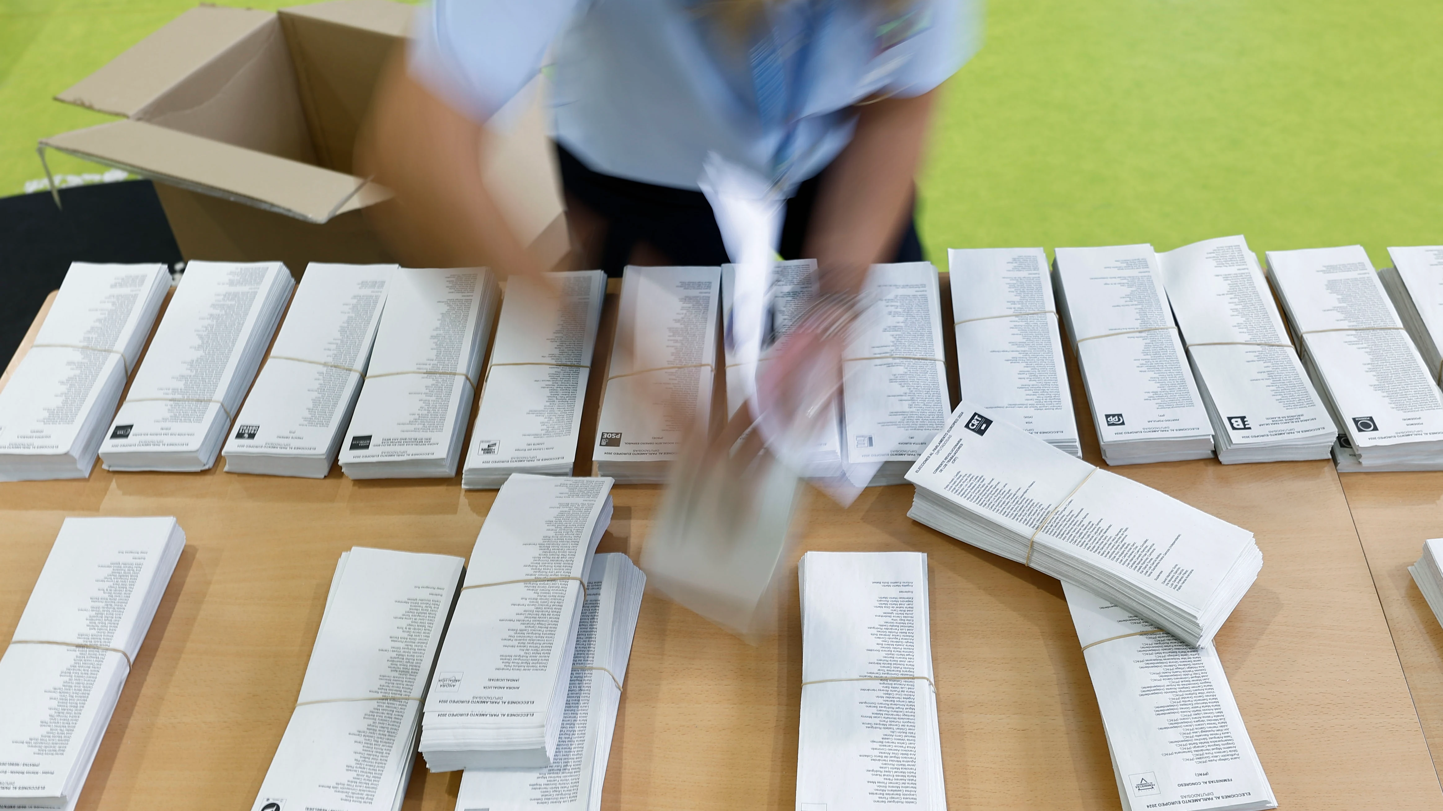 Una persona prepara las papeletas para la jornada electoral europea del 9-J, este sábado en el centro de votación en el colegio Blas de Lezo en Parla (Madrid)