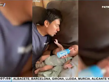 Así intenta coger el biberón un bebé cuando su padre se queda dormido mientras se lo da