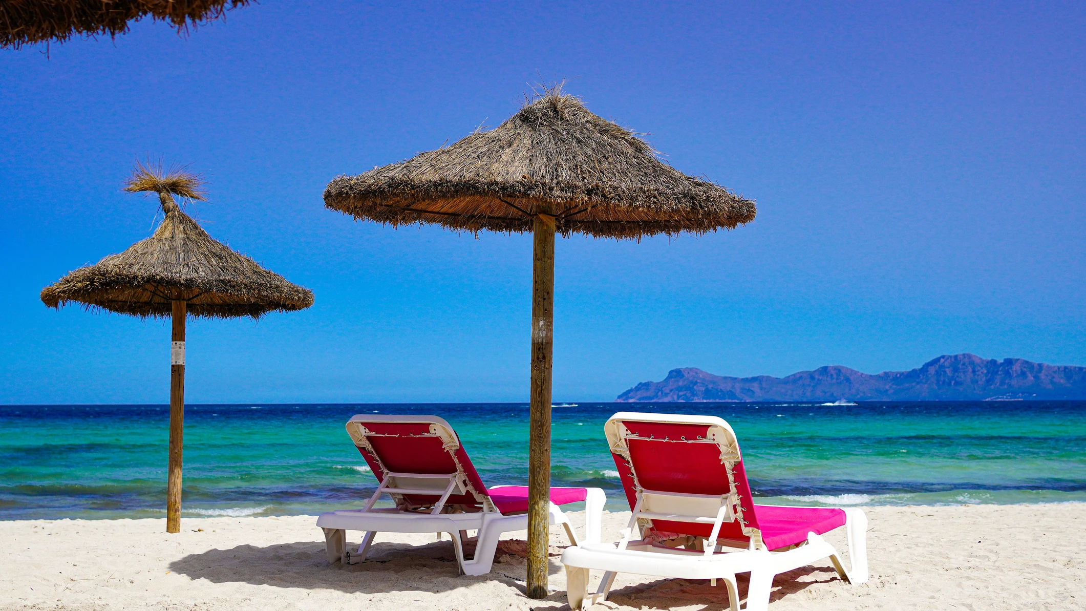 Sombrillas y hamacas en la playa de Muro, bahía de Alcúdia, en Mallorca Sombrillas y hamacas en la playa de Muro, bahía de Alcúdia, en Mallorca