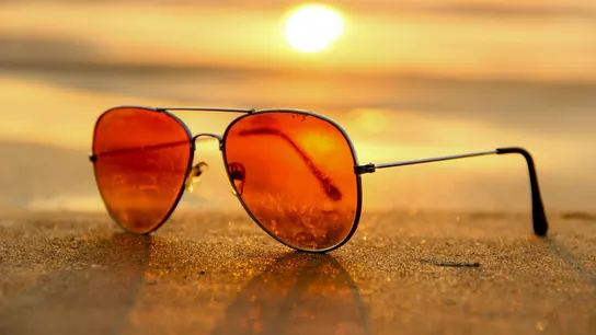 Unas gafas de sol sobre la arena de una playa en verano Unas gafas de sol sobre la arena de una playa en verano