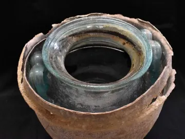 Urna y líquido usados para sumergir los restos óseos durante los rituales funerarios Urna y líquido usados para sumergir los restos óseos durante los rituales funerarios