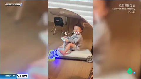 El juguete del futuro: una niña limpia la casa mientras conduce un cochecito eléctrico con mopa incluida