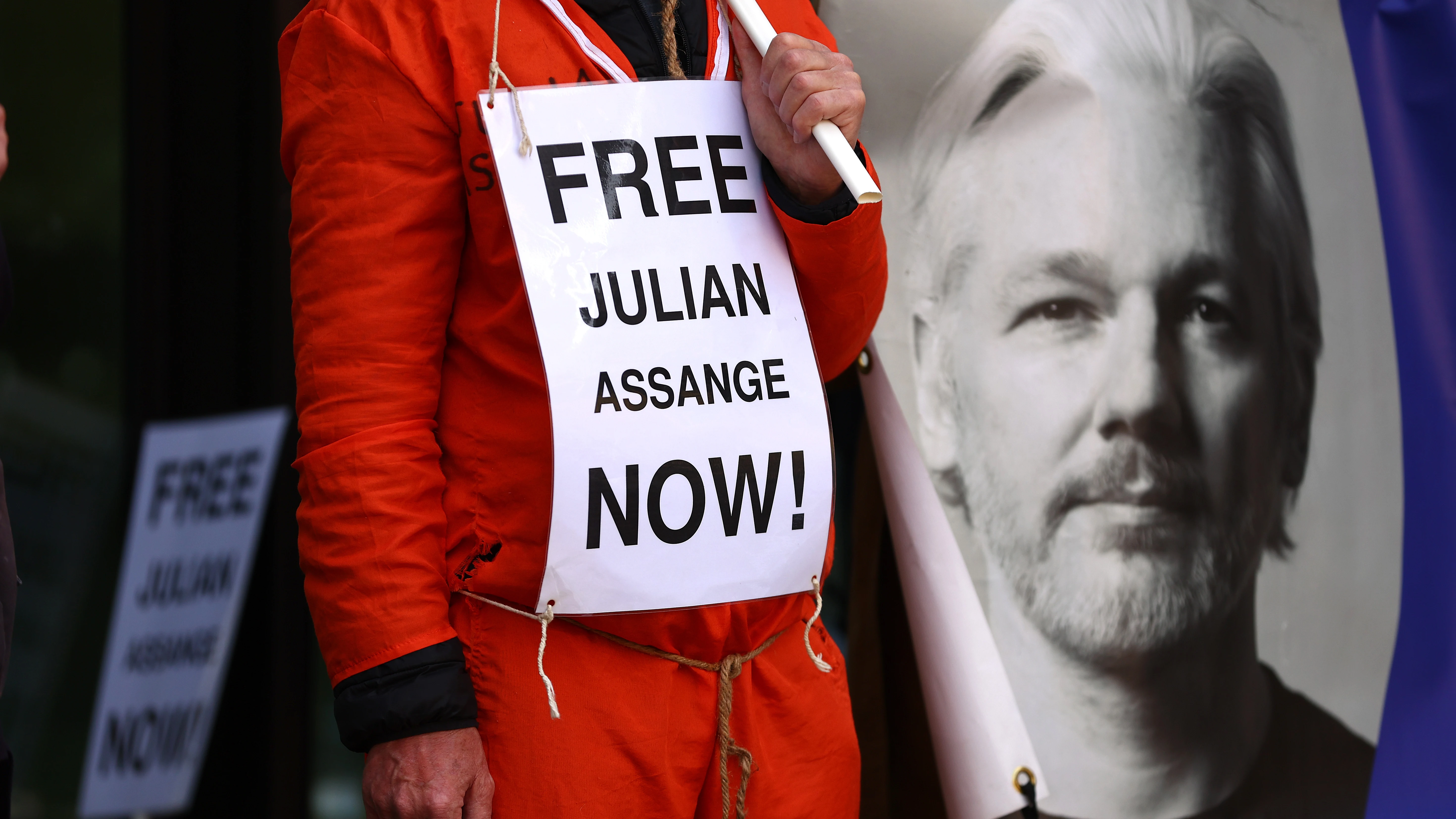 Un seguidor de Julian Assange, junto a una imagen del fundador de WikiLeaks, con un cartel en el que pide su liberación