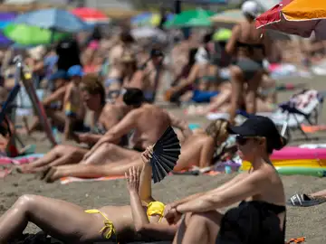 Una bañista se abanica en la playa de la Malagueta.