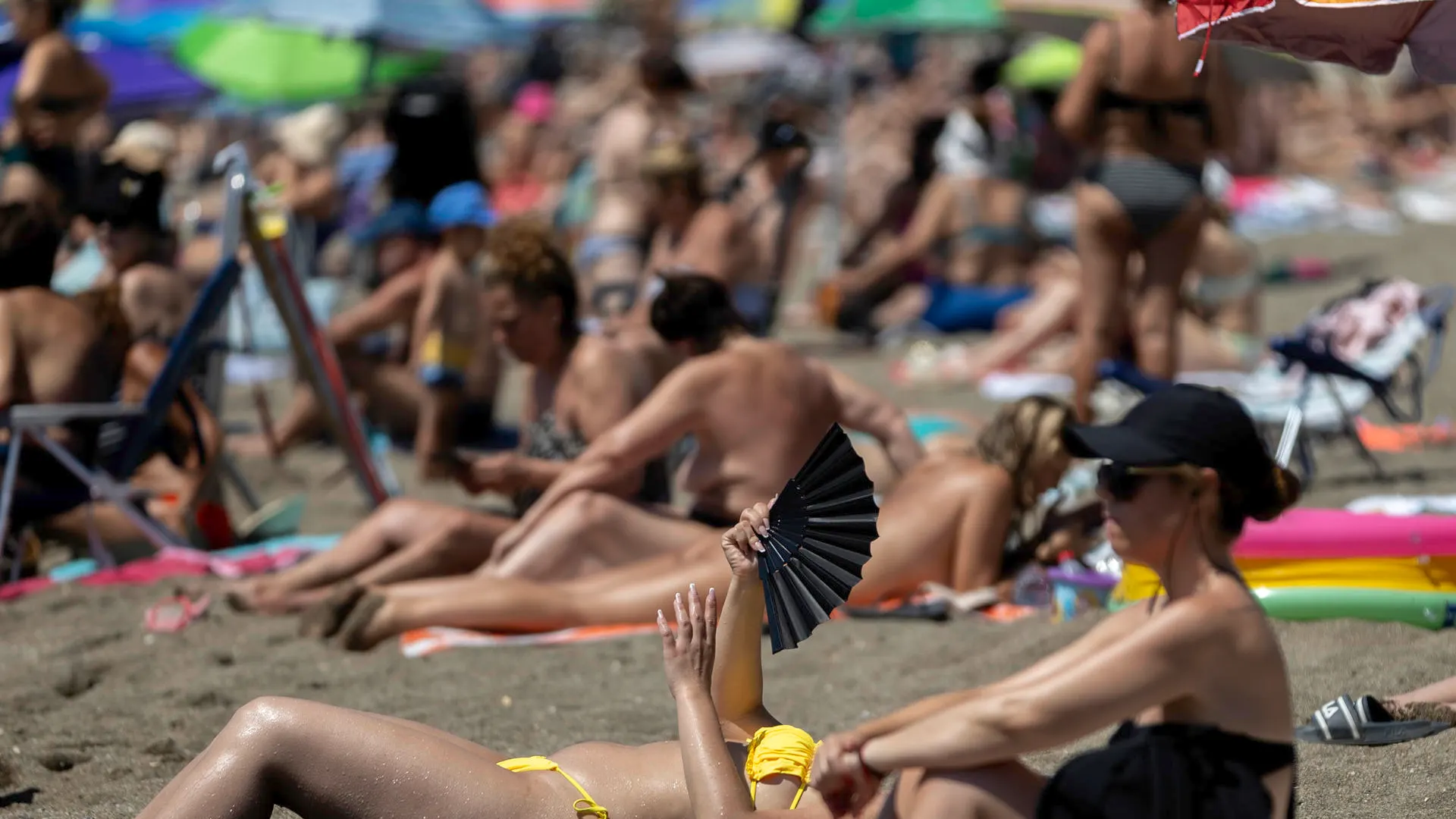 Una bañista se abanica en la playa de la Malagueta.