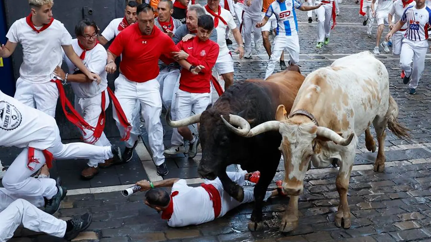 Un mozo cae al suelo durante el segundo encierro. Un mozo cae al suelo durante el segundo encierro.