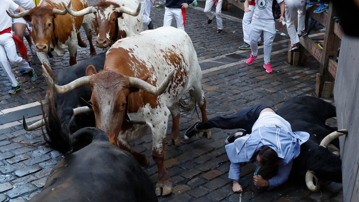 Un mozo y un toro caen durante el segundo encierro de los Sanfermines protagonizados por la ganader&iacute;a de los Herederos de D. Jos&eacute; Cebada Gago, de Medina Sidonia (C&aacute;diz), este lunes en Pamplona.