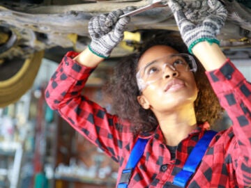 Mujer trabajando en un taller mecánico de coches.
