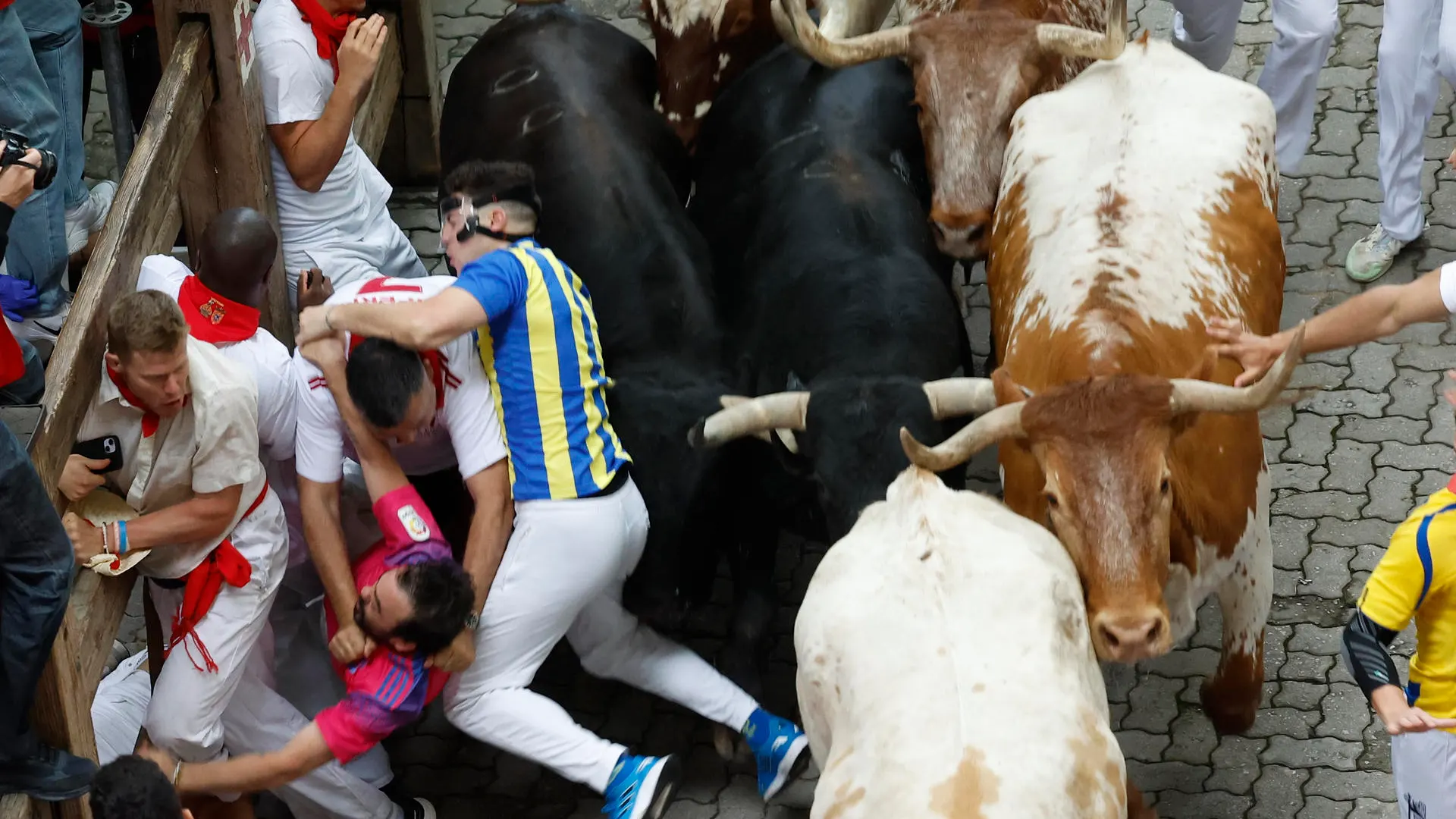 Mozos son perseguidos por toros de Victoriano del Río en el tercer encierro de los Sanfermines este martes, en Pamplona. 