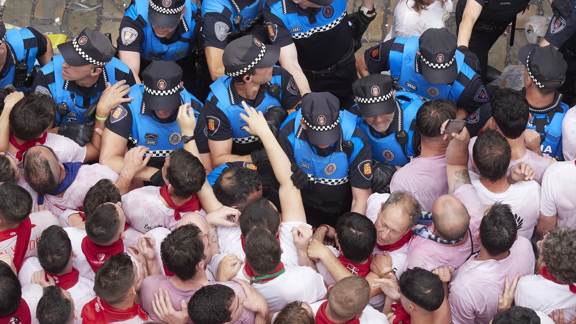 Agentes de Policía junto a decenas de personas durante el chupinazo que da inicio a los Sanfermines.