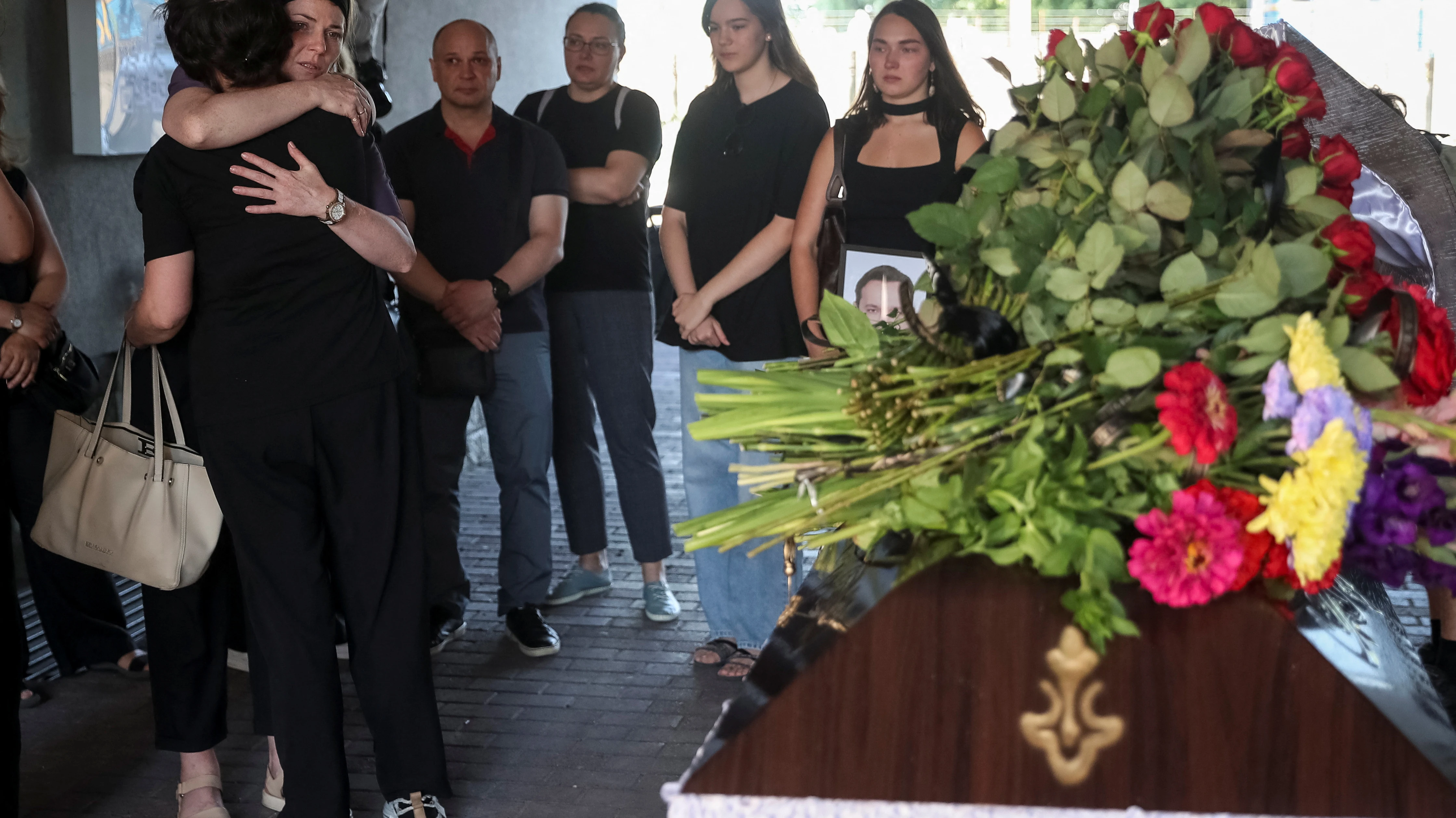Familiares y amigos reaccionan cerca del ataúd con el cuerpo del doctor Viktor Brahutsa.