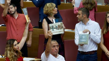 Varios diputados de Compromís muestran libros durante el pleno de Les Corts Valencianes en protesta por le ley de concordia