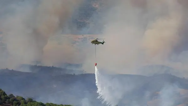 Un helicóptero del Infoca lanza agua sobre la zona incendiada
