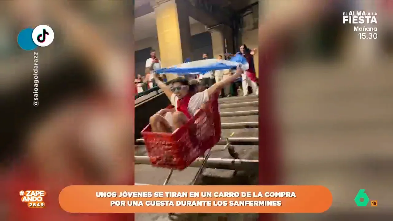 Un joven se tira subido en un carro por unas escaleras durante los sanfermines