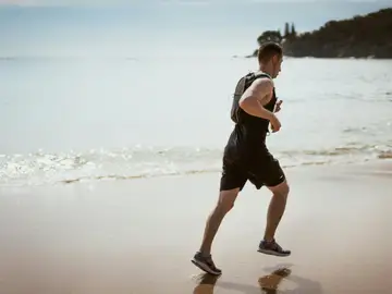 Un hombre practicando deporte en la playa Un hombre practicando deporte en la playa
