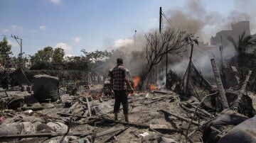 Palestinos inspeccionan la escena después de una incursión israelí contra las tiendas de campaña de los desplazados en la zona de Al Mawasi