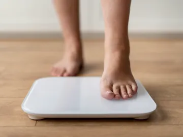 Persona pesándose en una báscula Persona pesándose en una báscula