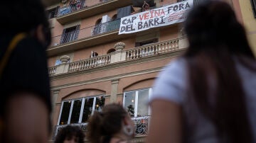 Un hombre con una pancarta en su balcón durante una manifestación contra el turismo masificado