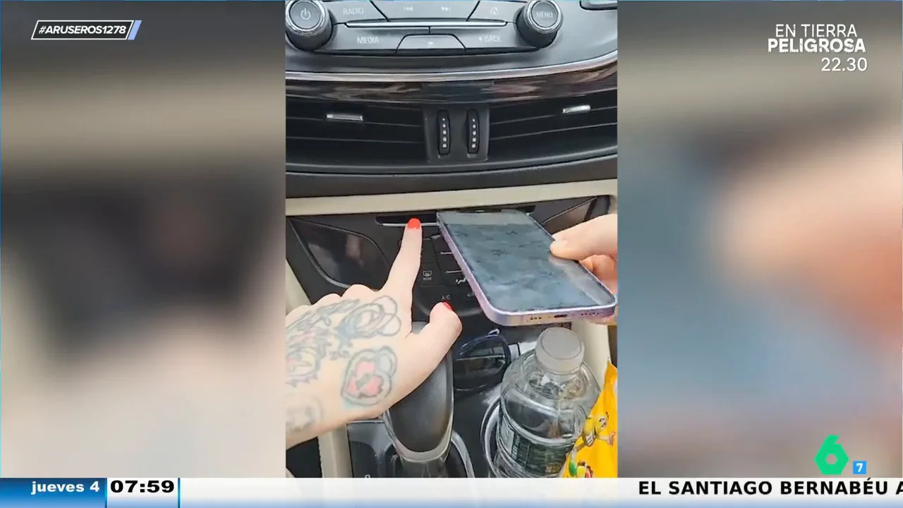 La cara de una madre al ver que su hija intenta encajar el móvil en el reproductor de CDs del coche