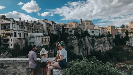 Unos jóvenes, en primer plano y con las Casas Colgadas de Cuenca al fondo. Unos jóvenes, en primer plano y con las Casas Colgadas de Cuenca al fondo.