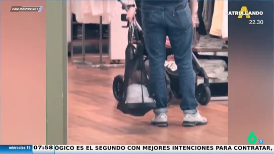 Un padre aprovecha la cesta de la compra para balancear a su hijo mientras pasea por la tienda Un padre aprovecha la cesta de la compra para balancear a su hijo mientras pasea por la tienda