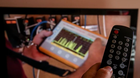 Una persona utiliza su mando de la televisión para buscar canales. Una persona utiliza su mando de la televisión para buscar canales.