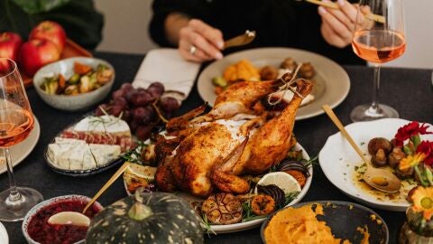 Mesa típica de celebración de Acción de Gracias, con el pavo asado en el centro.