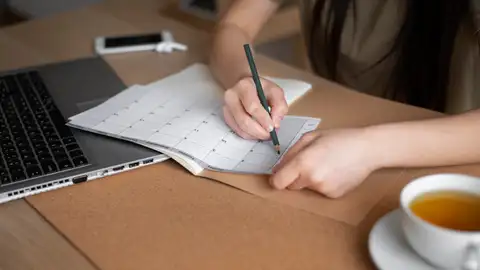 Una mujer planifica las tareas para aumentar la productividad Una mujer planifica las tareas para aumentar la productividad