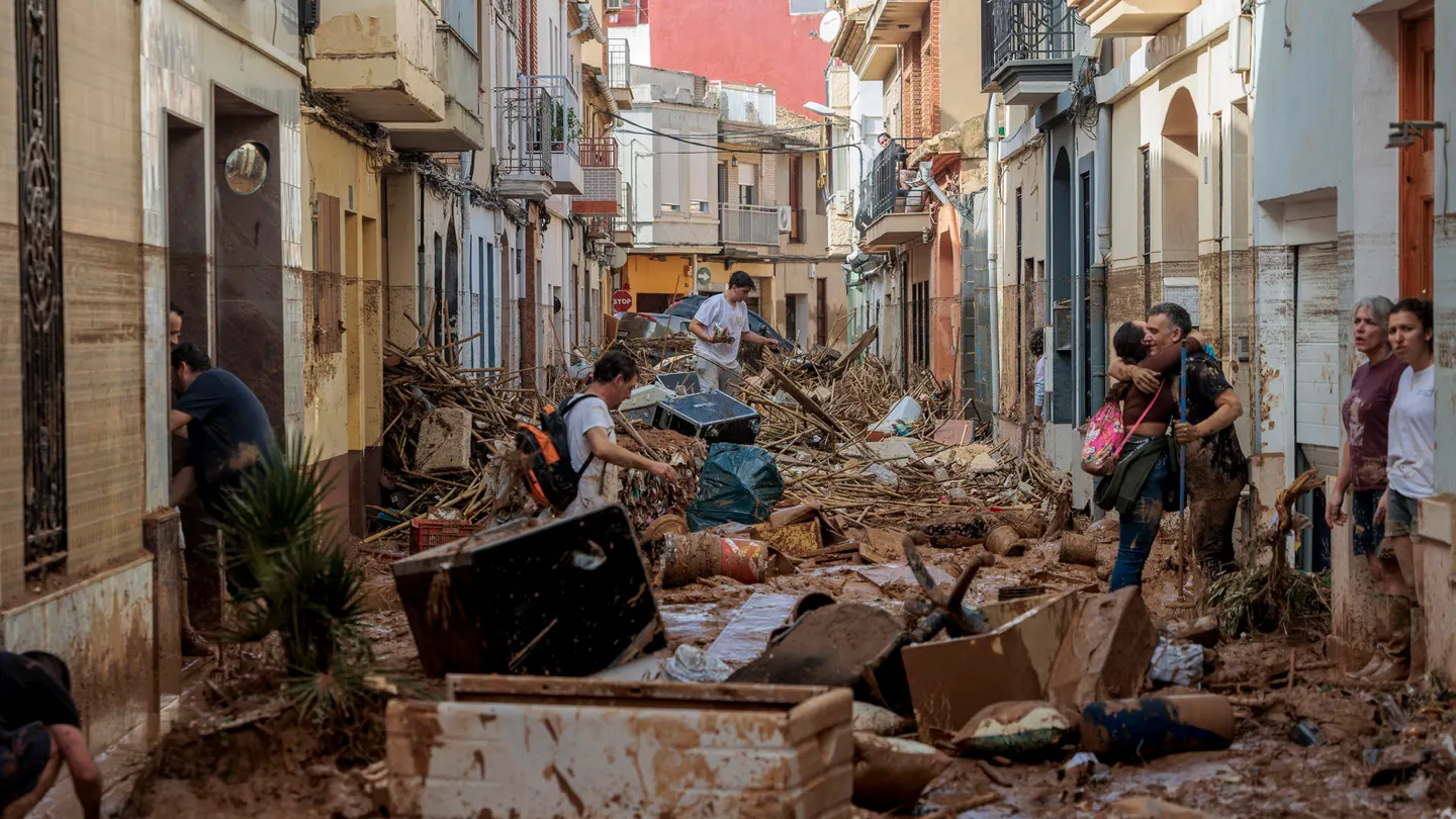 Vecinos intentan atravesar una calle en Paiporta cubierta de barro y enseres dos días después de la DANA. Vecinos intentan atravesar una calle en Paiporta cubierta de barro y enseres dos días después de la DANA.