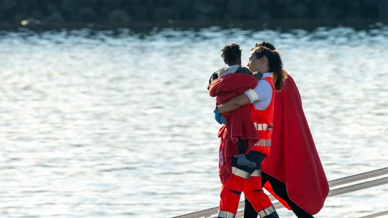 Trabajadora de la Cruz Roja lleva en brazos a un bebé, en una imagen de archivo. Trabajadora de la Cruz Roja lleva en brazos a un bebé, en una imagen de archivo.