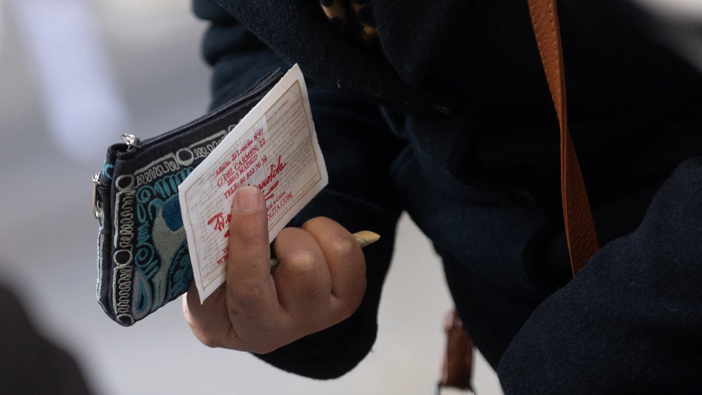 Una persona sujeta un décimo de la administración de lotería Doña Manolita de cara al Sorteo Extraordinario de la Lotería de Navidad, en la Administración de Loterías Doña Manolita, a 14 de diciembre de 2023, en Madrid (España). Una persona sujeta un décimo de la administración de lotería Doña Manolita de cara al Sorteo Extraordinario de la Lotería de Navidad, en la Administración de Loterías Doña Manolita, a 14 de diciembre de 2023, en Madrid (España).