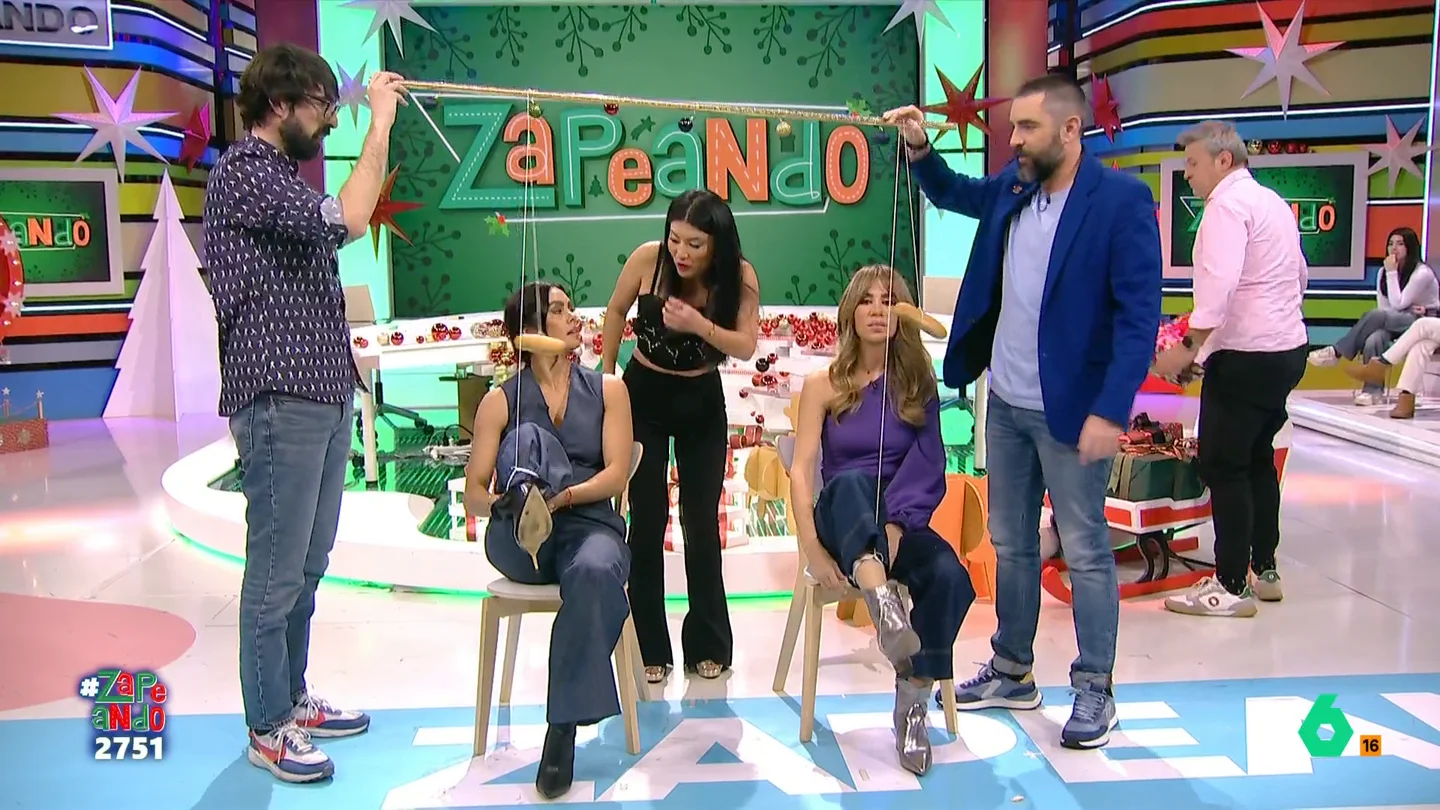 Cristina Pedroche, Miki Nadal, Jiaping y María Gómez se enfrentan en el 'Zampabollos' Los zapeadores deben enfrentarse en parejas para comerse un bollo sin usar las manos. Pero, para sumar más dificultad a este reto, el bollo va sujeto a una cuerda cuyo extremo va atado a su tobillo. ¿Quién conseguirá ganar?