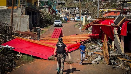 Un gendarme francés caminando entre los escombros en Mayotte tras el ciclón Chido Un gendarme francés caminando entre los escombros en Mayotte tras el ciclón Chido