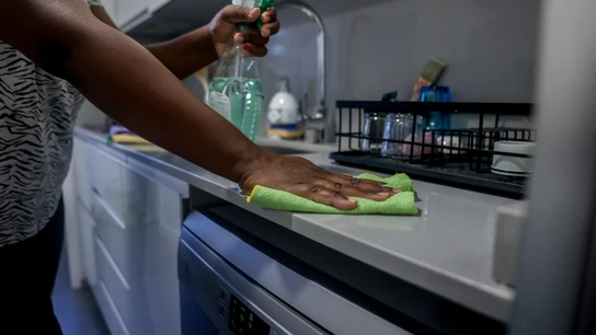 Una empleada de hogar limpia la encimera de la cocina Una empleada de hogar limpia la encimera de la cocina