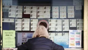 Una persona compra décimos de la Lotería de Navidad en Málaga.