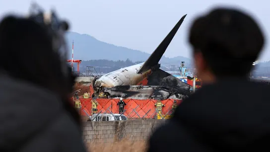 Dos personas observan el avión destruido de Jeju Air Dos personas observan el avión destruido de Jeju Air