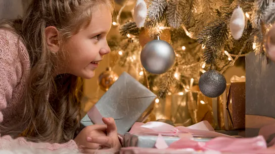 Un niña con regalos en Navidad Un niña con regalos en Navidad