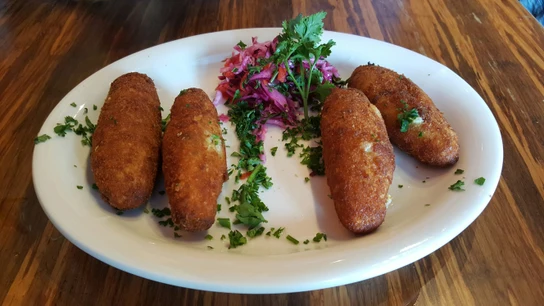 Un plato con cuatro croquetras caseras. Un plato con cuatro croquetras caseras.