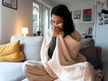 Mujer con tos y mocos por un resfriado Mujer con tos y mocos por un resfriado