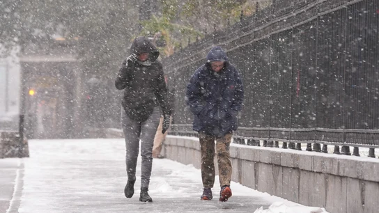 Dos personas caminando bajo la nieve en Nueva Orleans Dos personas caminando bajo la nieve en Nueva Orleans