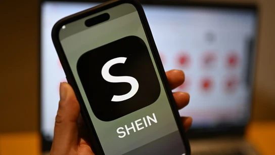 Imagen de archivo de una persona sosteniendo un móvil con el logotipo de Shein Imagen de archivo de una persona sosteniendo un móvil con el logotipo de Shein