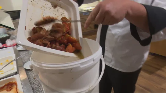Un cocinero guarda los restos de un plato de comida Un cocinero guarda los restos de un plato de comida