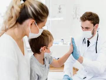 Un niño junto al personal médico en el hospital Un niño junto al personal médico en el hospital