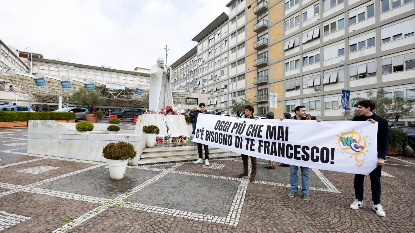 Varias personas con una pancarta de apoyo al papa Francisco cerca del hospital Gemelli