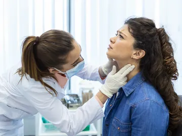 mujer a la que examinan la garganta mujer a la que examinan la garganta