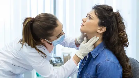 mujer a la que examinan la garganta mujer a la que examinan la garganta