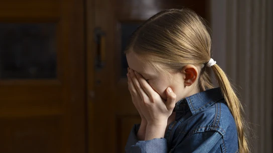 Una niña con las manos en la cara. Una niña con las manos en la cara.